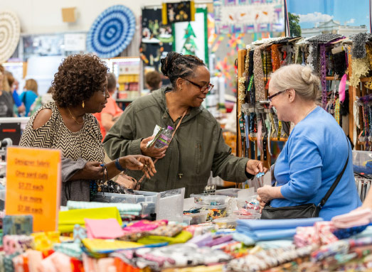 Three women looking at sewing supplies