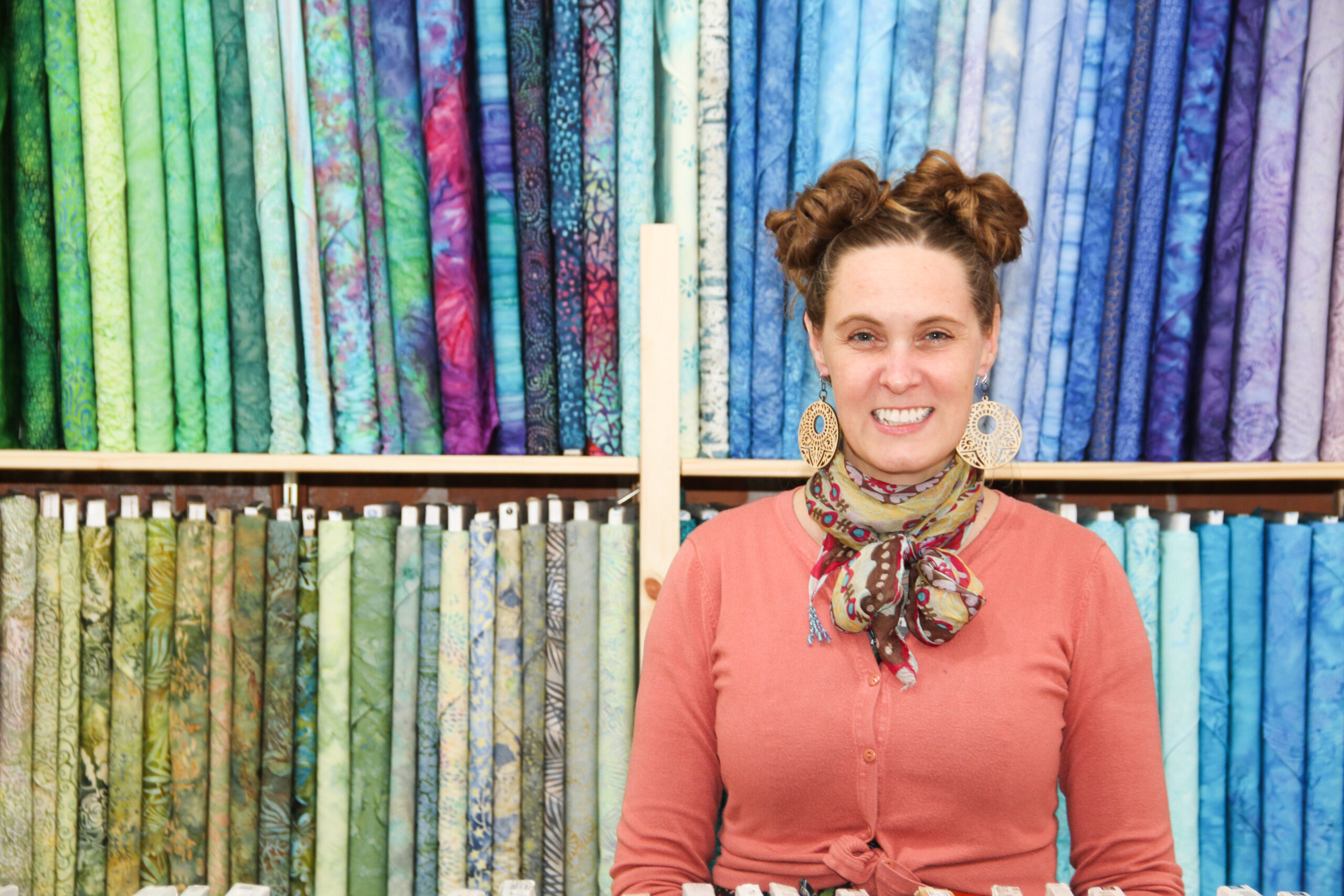 Woman standing in front of bolts of fabric