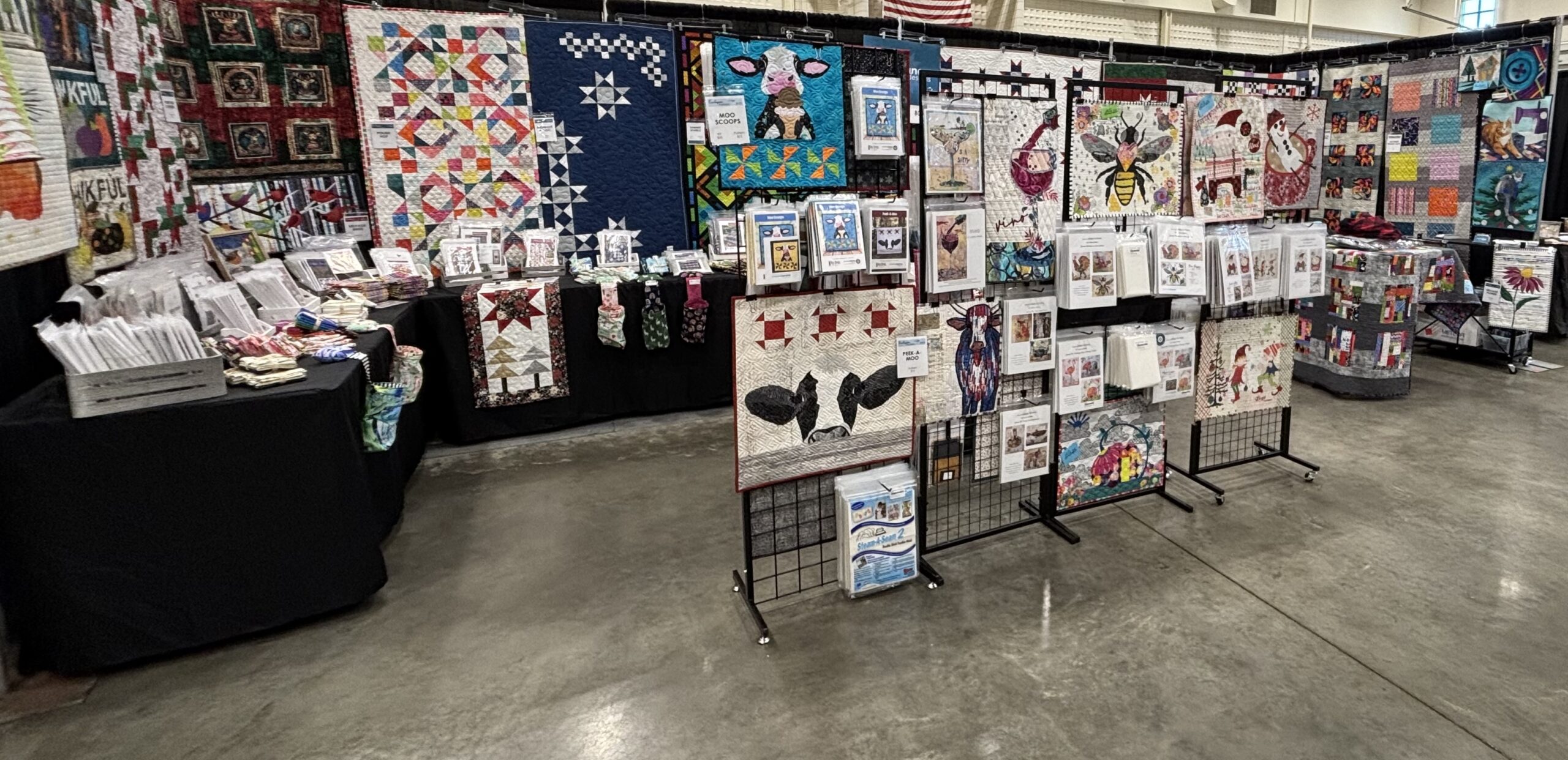 Booth set up showcases fabrics, patterns, and quilts