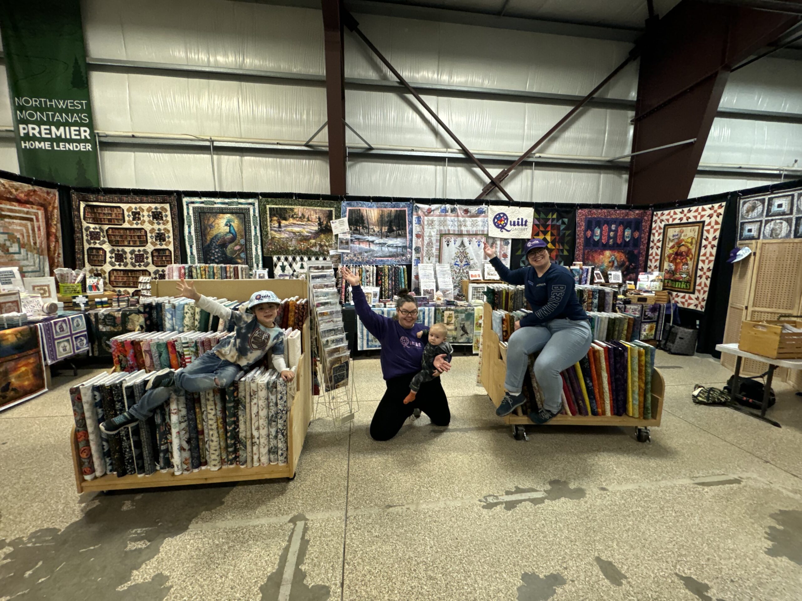 people with quilt booth display