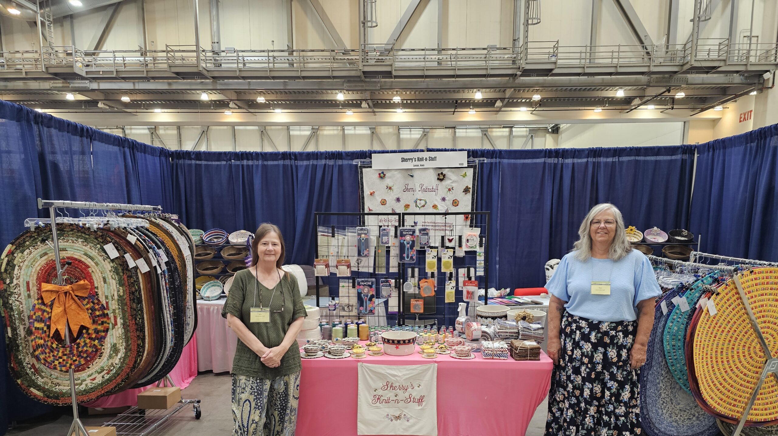 2 people standing in front of booth setup